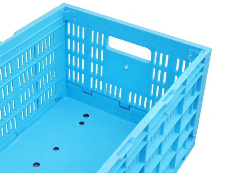 Blue collapsible plastic crate with ergonomic handles for farm distribution, enabling smooth manual handling in mixed environments.