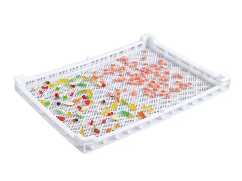 White stackable drying tray with colorful candies, for food drying.