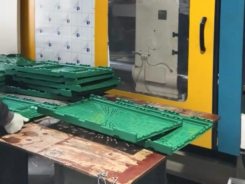 Green plastic crates at a workstation, part of supply chain operations.